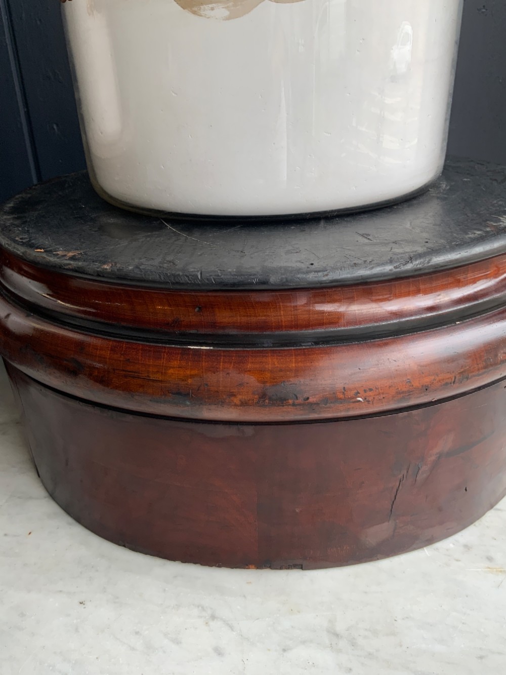 A pair of cylindrical glass apothecary jars with ornate gold leaf and blue labels set on turned circular mahogany display bases. View VI