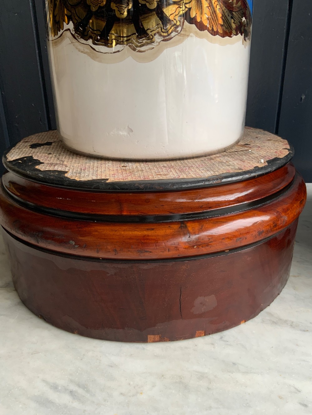 A pair of cylindrical glass apothecary jars with ornate gold leaf and blue labels set on turned circular mahogany display bases. View VII