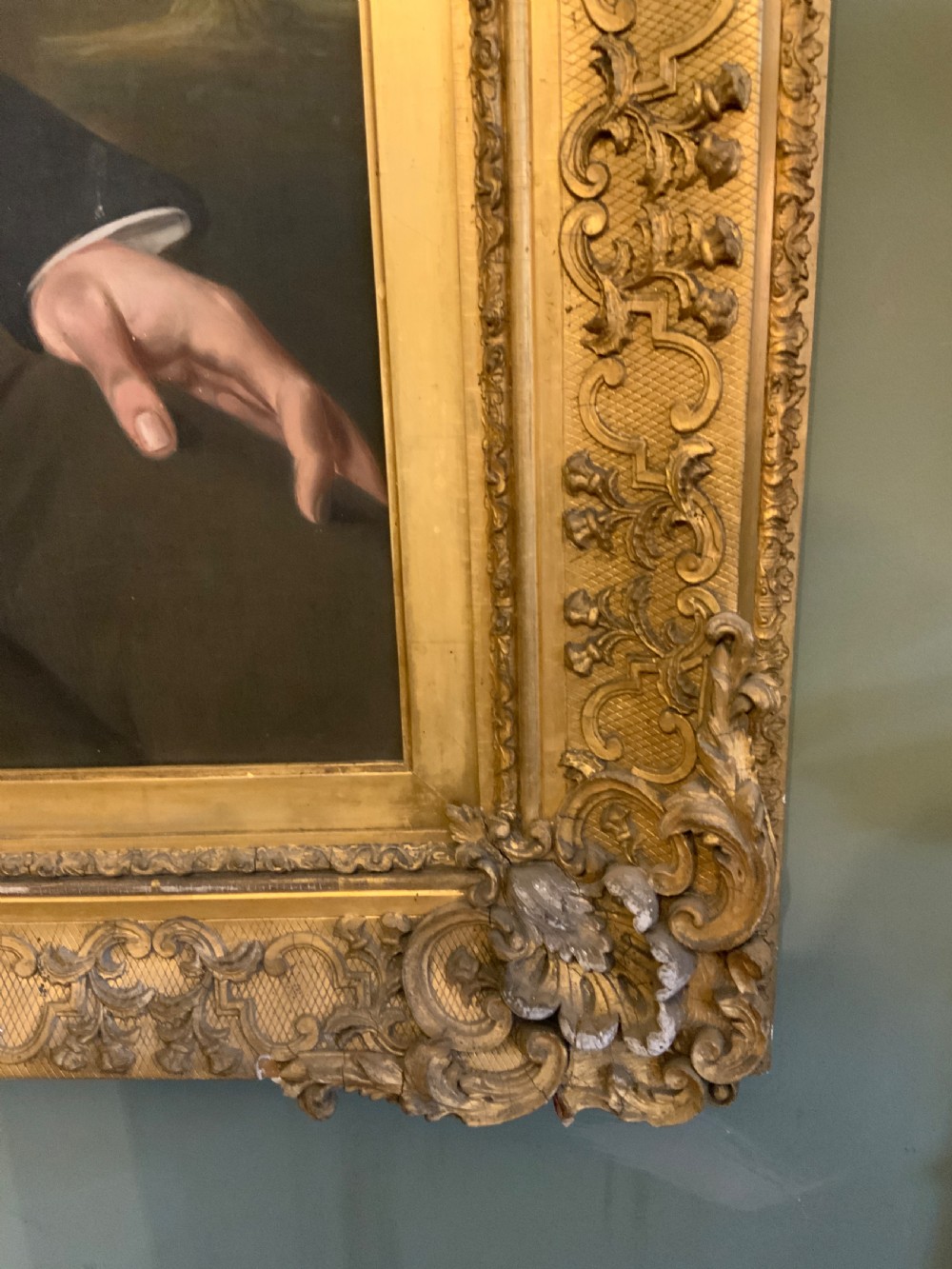 A 19th-century oil portrait of a gentleman in a dark suit seated within an ornate gilded frame. View IV