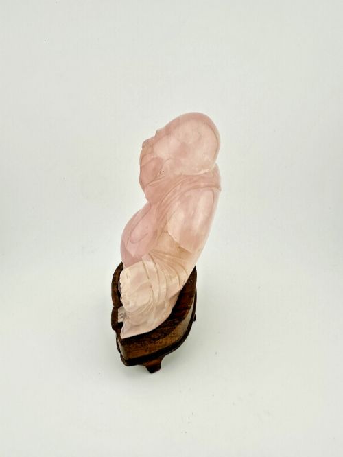 fig 2. A hand-carved pink rose quartz figure of a seated Laughing Buddha resting upon a custom dark wood stand.