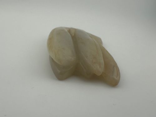 fig 4. A carved pale celadon jade sculpture depicting a cicada with folded wings and smooth polished surfaces.