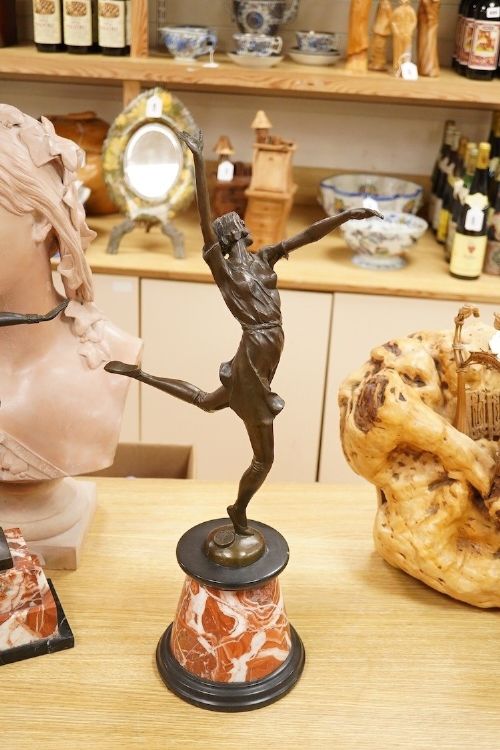 An Art Deco style bronze sculpture of a female dancer in mid-leap mounted on a rounded variegated orange marble base. View VI