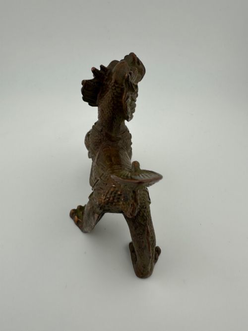 fig 3. A small patinated dark brown bronze figure of a Chinese mythical beast, standing on four legs with an open mouth and raised tail.