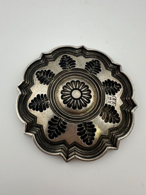 fig 4. A lobed Chinese white metal dish with raised relief repousse lotus foliage and a central floral motif.