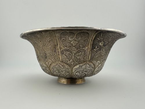 fig 8. A lobed silver white metal bowl decorated with hand-chased panels of birds and flowers on a textured ground.