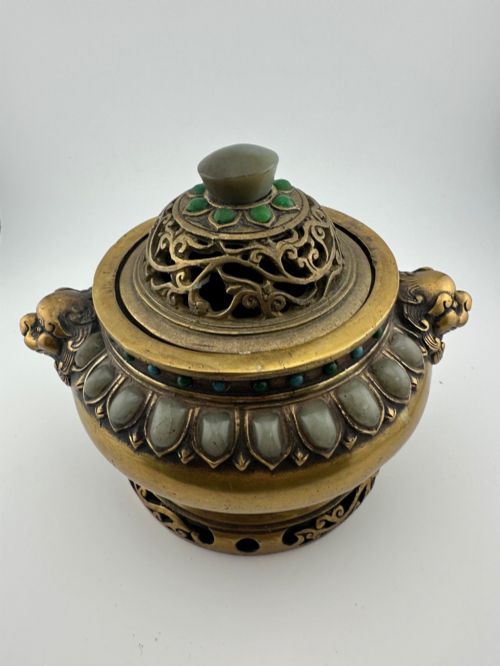 fig 1. An antique gilded bronze Chinese censer featuring hardstone and jade cabochon inlays, beast-head handles, a pierced cover, and a matching carved stand.