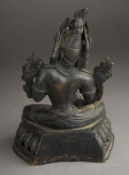 fig 1. A dark bronze figure of the Buddhist deity Tara seated in lalitasana on an ornate lotus base.