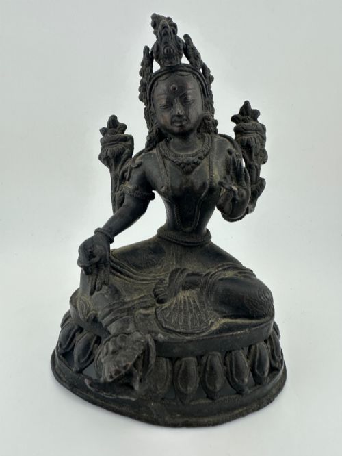 fig 3. A dark bronze figure of the Buddhist deity Tara seated in lalitasana on an ornate lotus base.
