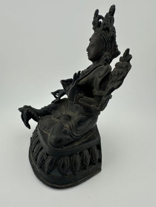 fig 4. A dark bronze figure of the Buddhist deity Tara seated in lalitasana on an ornate lotus base.