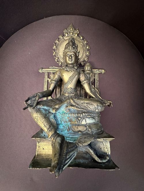 fig 1. An antique cast bronze figure of Green Tara seated on an elaborate throne with a flaming halo backpiece and visible green patination.