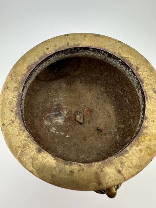 fig 4. A rounded antique brass Chinese censer featuring a flared rim, pedestal base, and sculpted lion mask handles on either side.