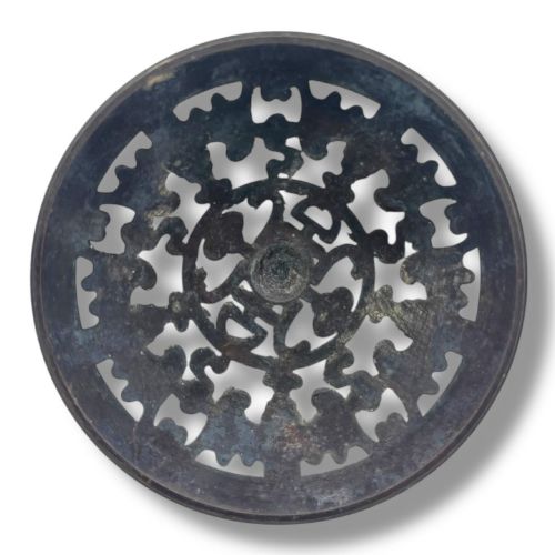 fig 6. A Chinese bronze tripod censer featuring a compressed circular body, three tapered feet, and a reticulated lotus lid topped with a pointed finial.
