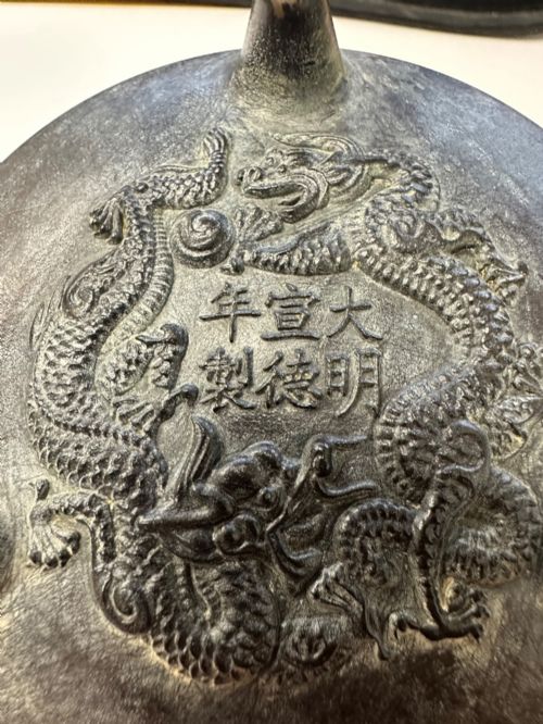 fig 7. A Chinese bronze tripod censer featuring a compressed circular body, three tapered feet, and a reticulated lotus lid topped with a pointed finial.