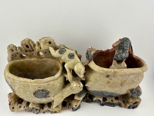 fig 1. An antique Chinese carved soapstone double brush washer featuring two vessel shapes supported by carved animals and pierced rockwork in shades of mottled green, cream, and dark grey.