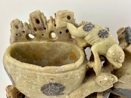 fig 2. An antique Chinese carved soapstone double brush washer featuring two vessel shapes supported by carved animals and pierced rockwork in shades of mottled green, cream, and dark grey.