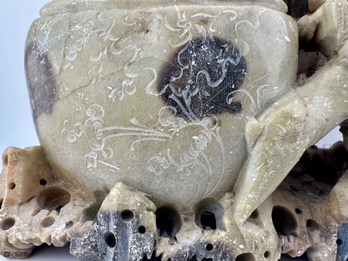 fig 4. An antique Chinese carved soapstone double brush washer featuring two vessel shapes supported by carved animals and pierced rockwork in shades of mottled green, cream, and dark grey.