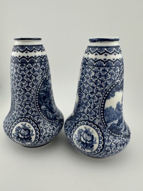 fig 2. A pair of antique blue and white ceramic vases featuring central pastoral vignettes framed by elaborate scrollwork patterns.