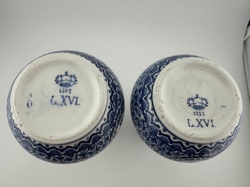 fig 1. A pair of antique blue and white ceramic vases featuring central pastoral vignettes framed by elaborate scrollwork patterns.