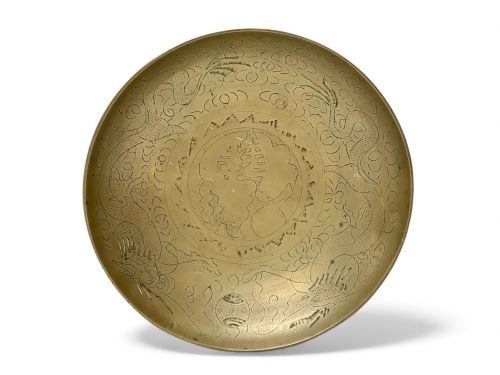 fig 2. A circular shallow brass dish featuring detailed hand-engraved designs of dragons, clouds, and a central circular motif.