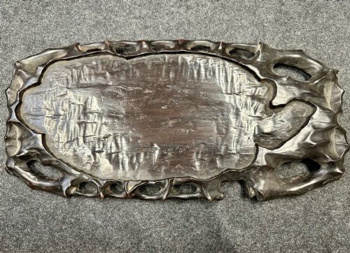 fig 5. A late Qing Dynasty dark carved hardwood figure depicting a reclining Budai resting on an openwork carved wooden base.