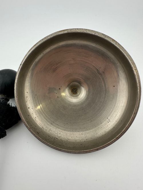 fig 5. An antique domed Indian brass hand gong with detailed floral engravings, a turned central finial handle, and a dark wooden striker.