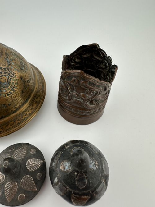 fig 3. A five-piece group of antique Persian Qajar metalware, including an engraved brass incense burner lid with a finial, a dark carved vessel collar, and three small circular lids.