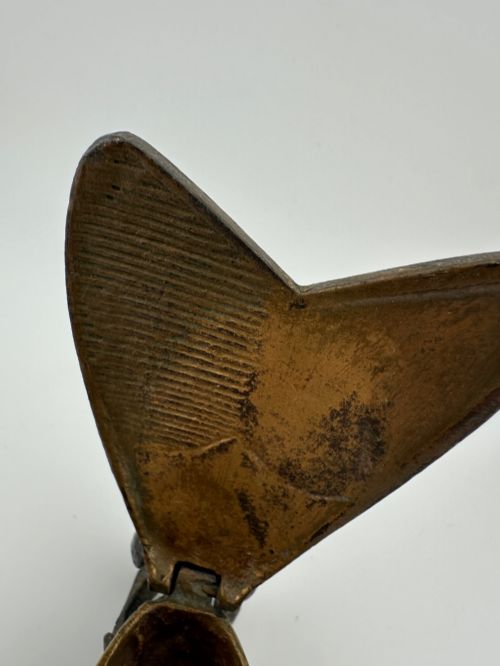 fig 3. A cast dark brass match holder sculpted in the detailed shape of a fly with textured wings, compound eyes, and six legs.