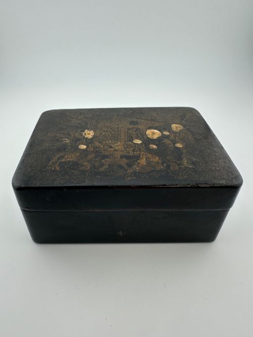 fig 2. An early 19th-century rectangular black lacquer box with gilded painted Chinese figural scenes on the lid.