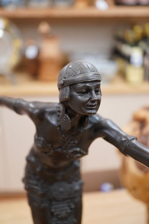 fig 1. An Art Deco style dark bronze figurine depicting an exotic female dancer with outstretched arms mounted on a stepped red and white marble plinth.