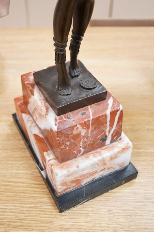 fig 3. An Art Deco style dark bronze figurine depicting an exotic female dancer with outstretched arms mounted on a stepped red and white marble plinth.