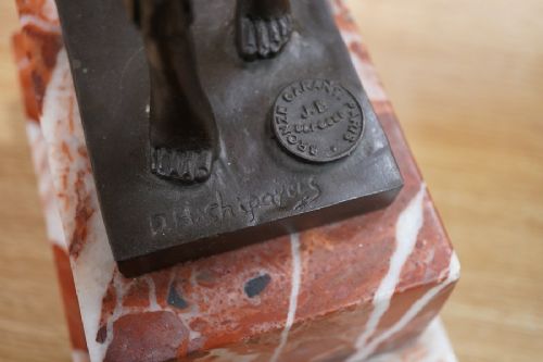 fig 4. An Art Deco style dark bronze figurine depicting an exotic female dancer with outstretched arms mounted on a stepped red and white marble plinth.