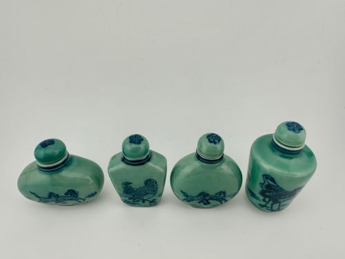 fig 1. A set of four celadon-green porcelain snuff bottles painted with underglaze blue depictions of horses and birds.