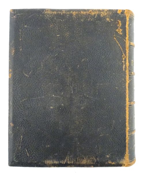 fig 5. A dark leather-bound Victorian Holy Bible featuring gilt lettering inside a star-shaped frame and decorative brass corner mounts.