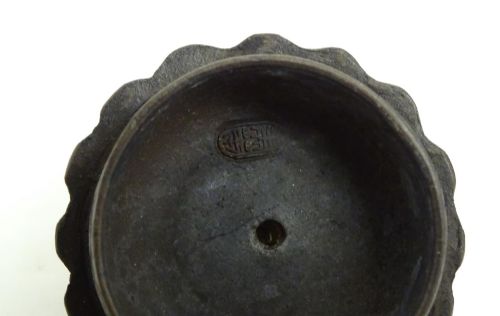 fig 6. A small dark brown unglazed ceramic teapot featuring a lobed body and a bird-shaped finial on the lid.
