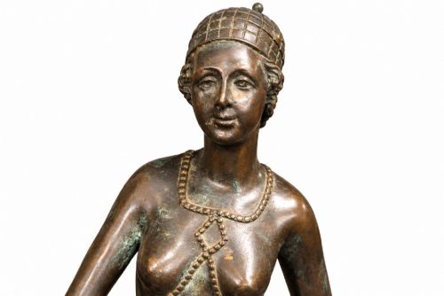 fig 3. A dark bronze Art Deco sculpture depicting a stylised woman walking two greyhounds on thin chains, set on a dark polished marble base.