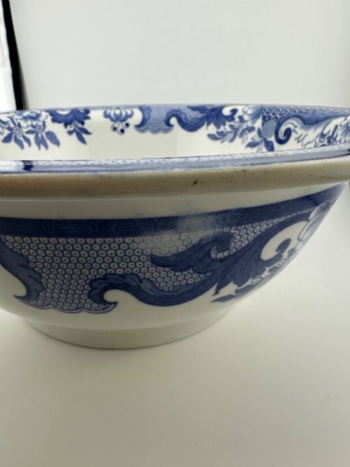 fig 3. A circular antique blue and white ironstone wash basin bowl featuring a central Chinoiserie landscape scene surrounded by ornate floral and geometric borders.