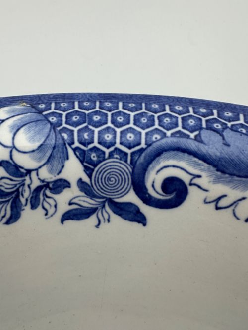 fig 4. A circular antique blue and white ironstone wash basin bowl featuring a central Chinoiserie landscape scene surrounded by ornate floral and geometric borders.
