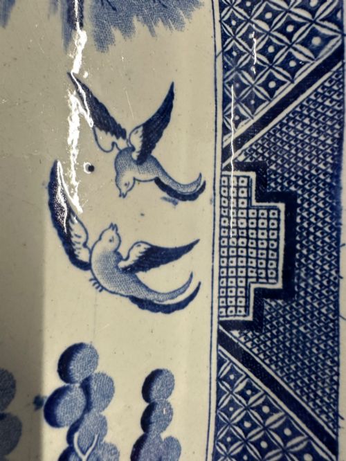 fig 2. An oval early Victorian Staffordshire earthenware meat platter featuring a cobalt blue and white transferware Willow pattern with pagodas, birds, and a decorative geometric border.