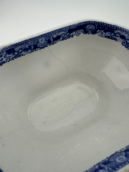 fig 2. An antique oval ironstone jardiniere featuring blue and white transfer-printed Chinoiserie landscape decoration and small side handles with gilded detailing.