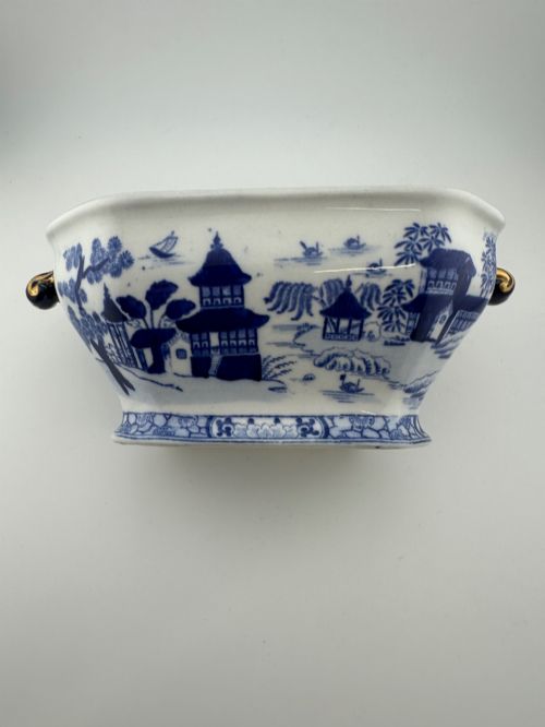 fig 4. An antique oval ironstone jardiniere featuring blue and white transfer-printed Chinoiserie landscape decoration and small side handles with gilded detailing.