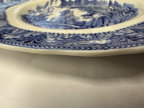 fig 2. An octagonal-edged blue and white transferware plate featuring a central classical chariot scene surrounded by an ornate feather-patterned border.