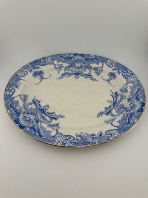 fig 1. An early Victorian oval earthenware platter featuring a pale blue floral transferware border pattern and a gilded outer rim.