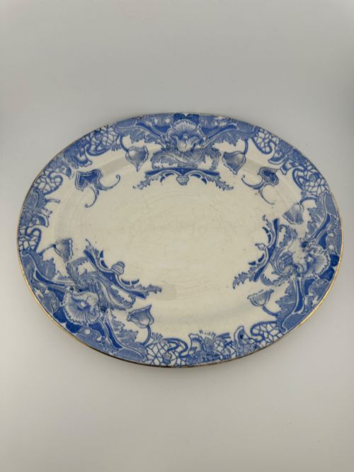 fig 2. An early Victorian oval earthenware platter featuring a pale blue floral transferware border pattern and a gilded outer rim.