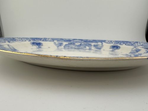 fig 4. An early Victorian oval earthenware platter featuring a pale blue floral transferware border pattern and a gilded outer rim.