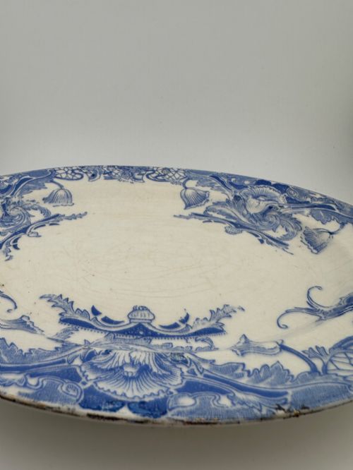 fig 5. An early Victorian oval earthenware platter featuring a pale blue floral transferware border pattern and a gilded outer rim.