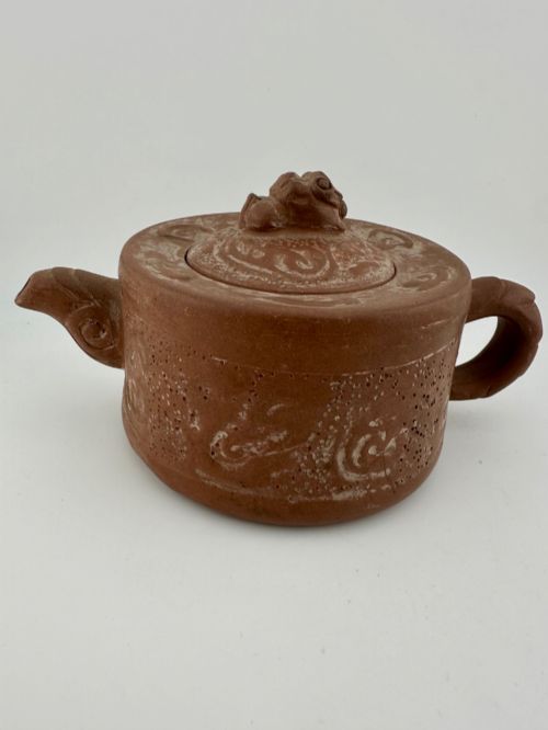fig 2. An antique brown Zisha clay teapot featuring archaistic relief decoration and a toad finial on the lid.