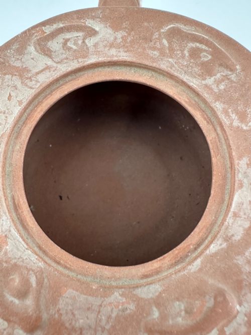 fig 7. An antique brown Zisha clay teapot featuring archaistic relief decoration and a toad finial on the lid.