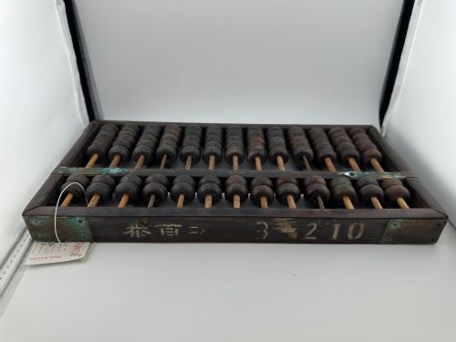 fig 3. A rectangular dark hardwood Chinese suanpan abacus with two upper beads and five lower beads per rod, reinforced with oxidised brass plates.