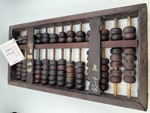 fig 4. A rectangular dark hardwood Chinese suanpan abacus with two upper beads and five lower beads per rod, reinforced with oxidised brass plates.