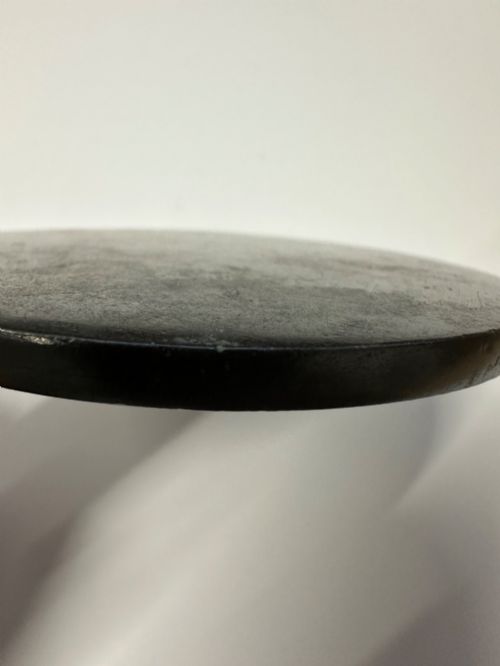 fig 4. A circular ancient bronze mirror back featuring a prominent central knob, raised concentric circular borders, and stylized dragon motifs in low relief.